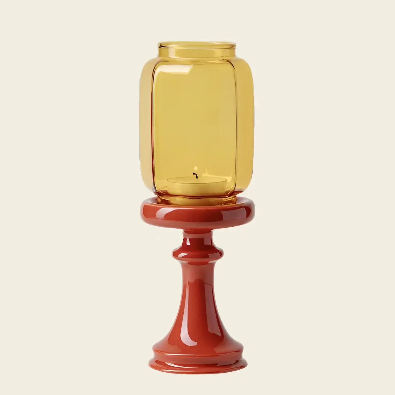 Yellow glass candle holder on a red stand against a beige background