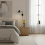 Modern bedroom with a bed, nightstand, lamp, and abstract art on the wall.