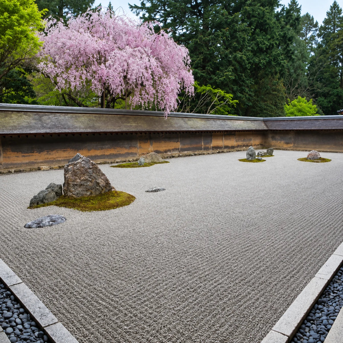 Wooden Zen Garden tray with raked white sand, natural stones, and a bamboo rake.