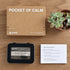 Zenify Pocket of Calm packaging box, closed metal tin and 3-Minute Desk Ritual instruction card on a wooden table.