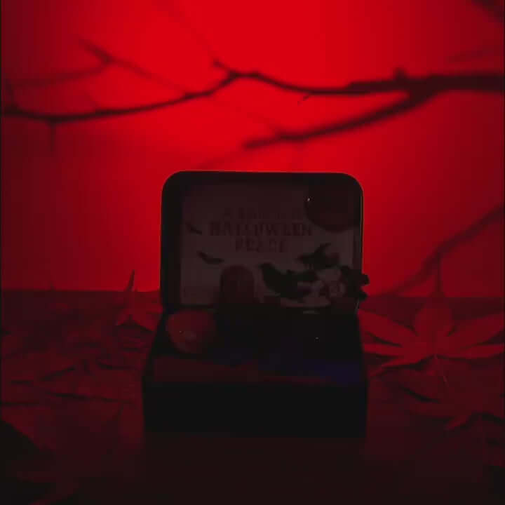 Zenify Halloween Obsidian Pocket Garden in red light, featuring a crystal, mini pumpkins, and a raven.