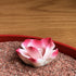 Close-up of the pink lotus incense holder in the red Zen garden