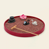 Red oval Zen garden with red sand, stacked stones, lotus, black and white swans, and bamboo rake