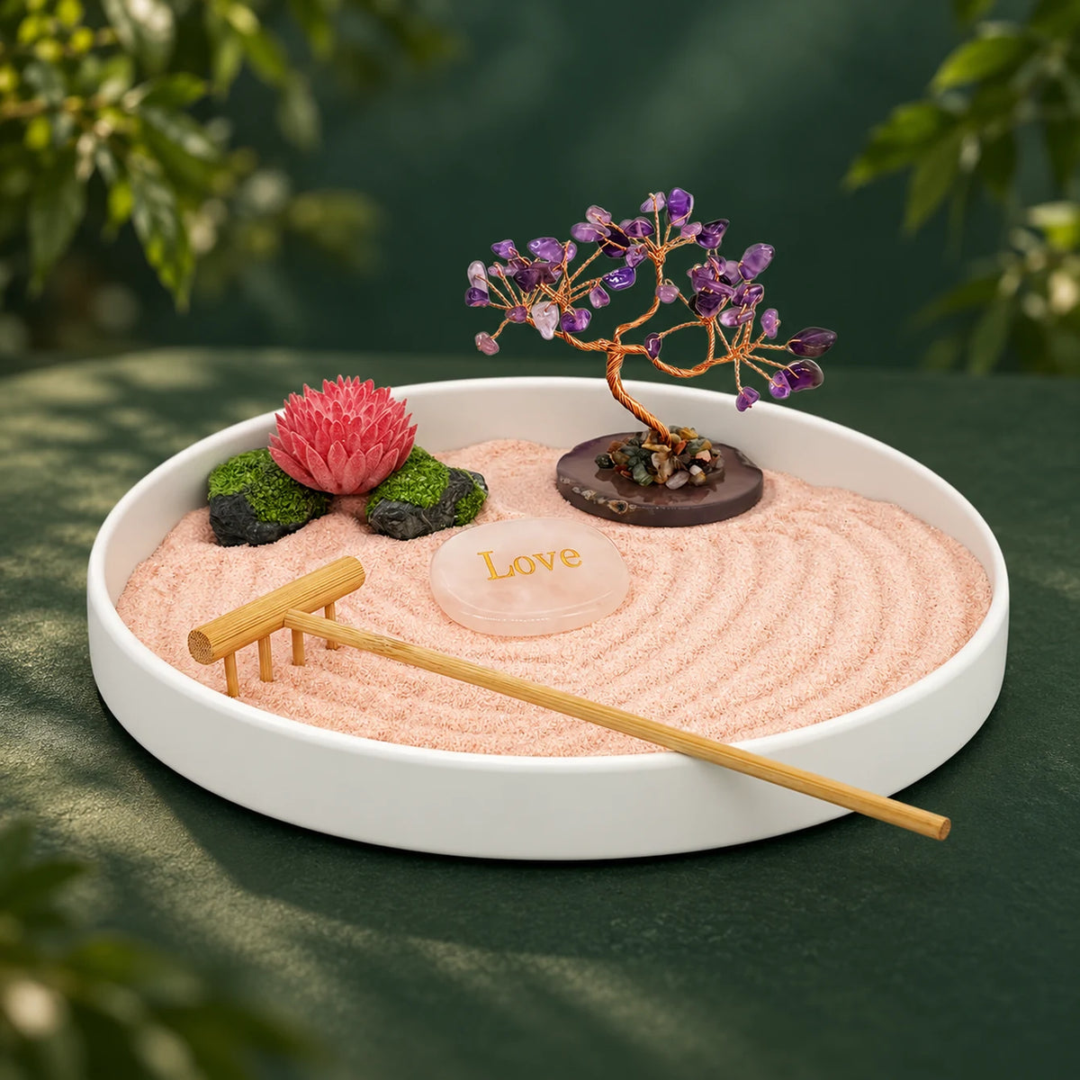 Love & Peace Zen Garden with a purple crystal tree, lotus, pink sand, Love stone and bamboo rake in a white tray on a forest-green surface.