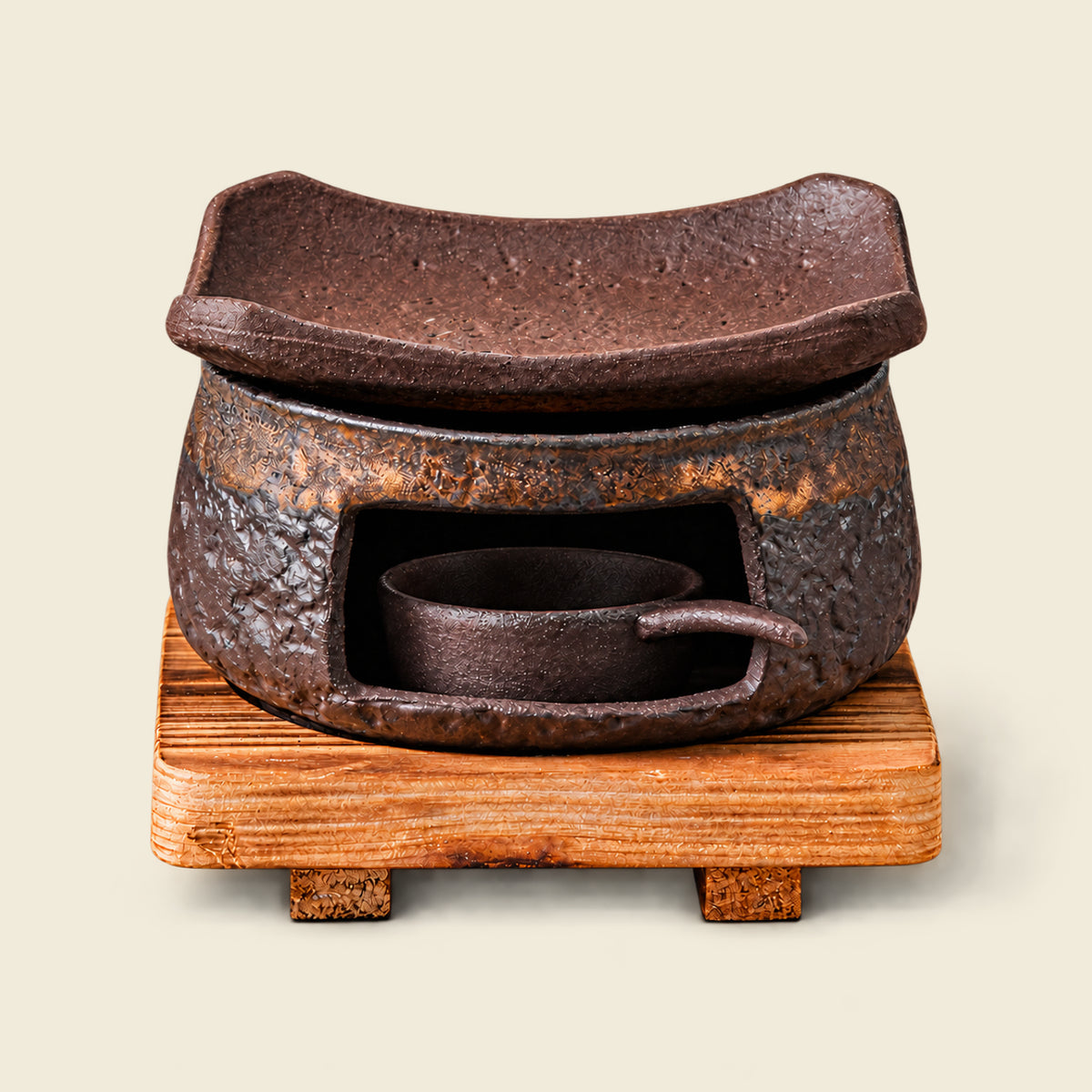 Brown ceramic incense warmer with a curved dish and empty handled candle cup on a square wooden base.